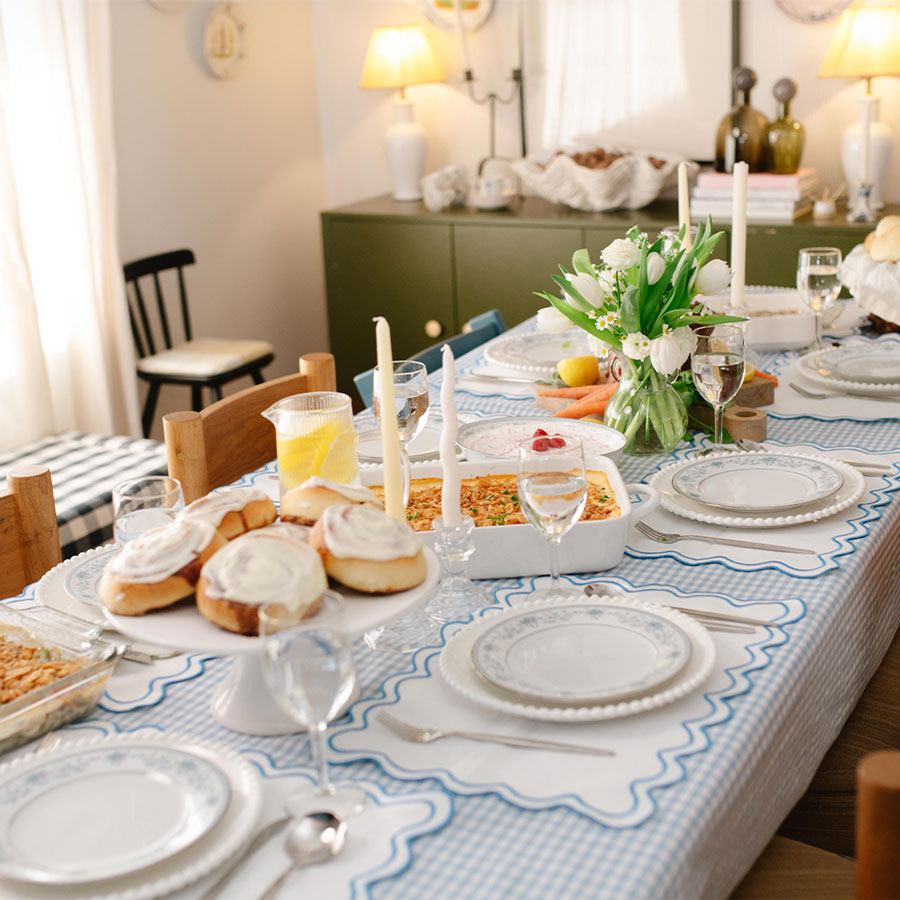 Dining table set for a meal with plates, glasses, and a centerpiece.