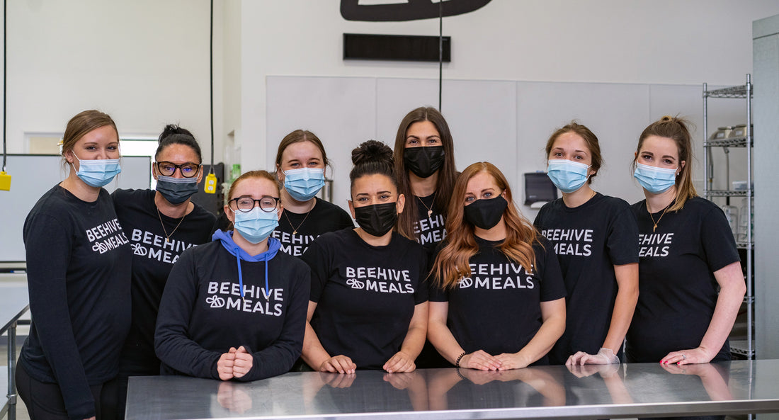 Beehive Meals employees posing in prep kitchen wearing face masks.