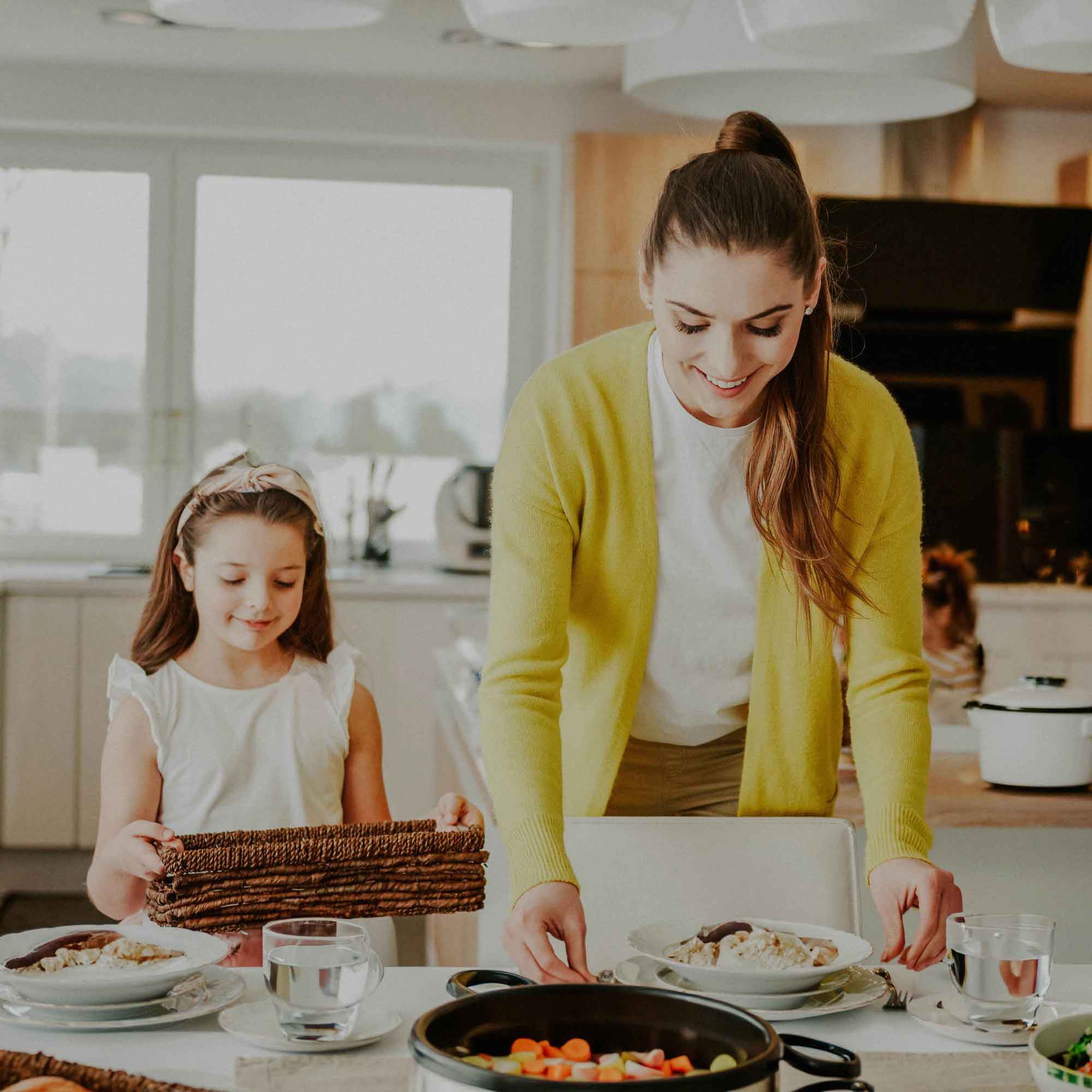 smiling-mother-and-daughter-setting-the-table-at-h-2022-12-16-22-07-12-utc-4-2.jpg